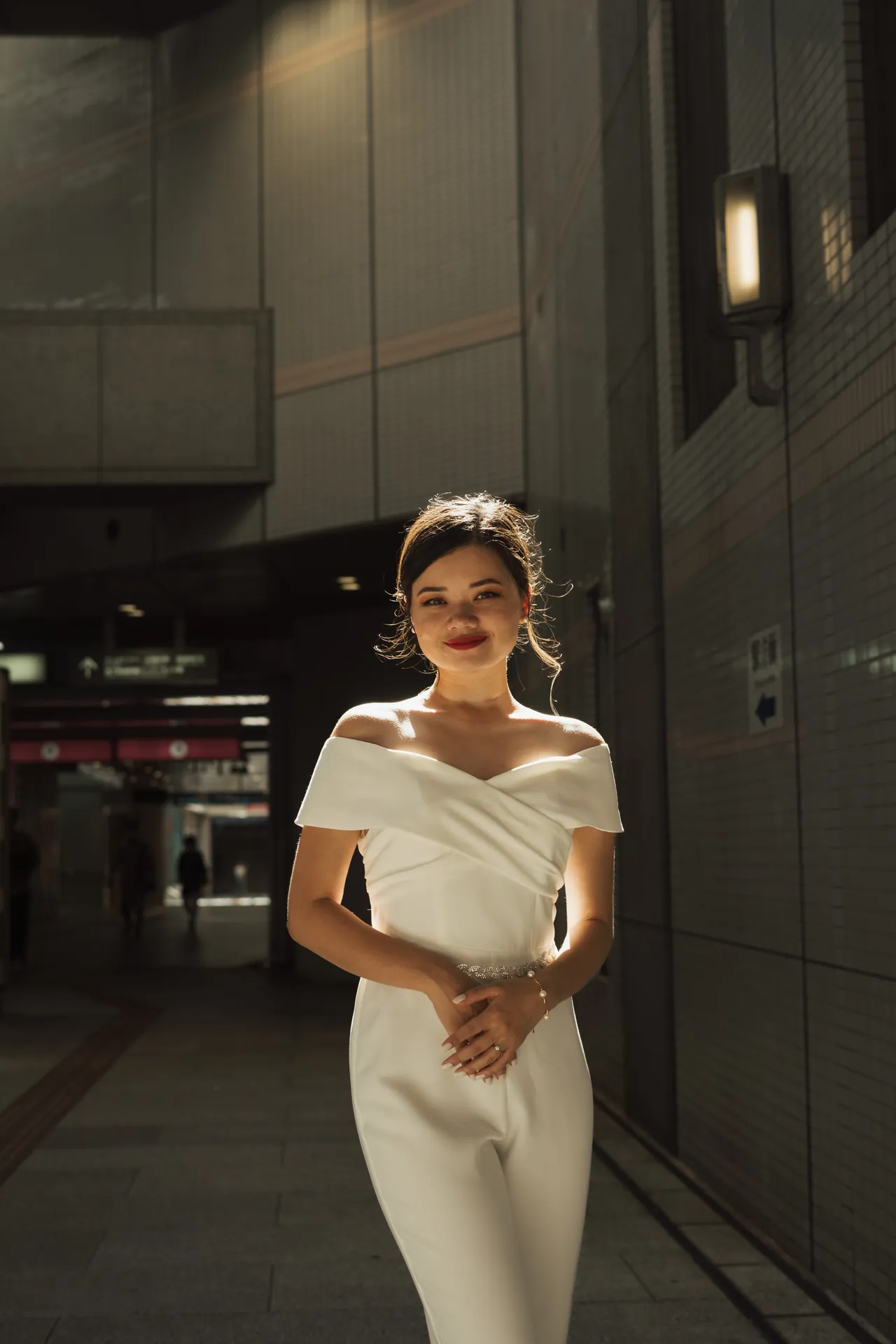 Retrato de mulher de branco num corredor da cidade