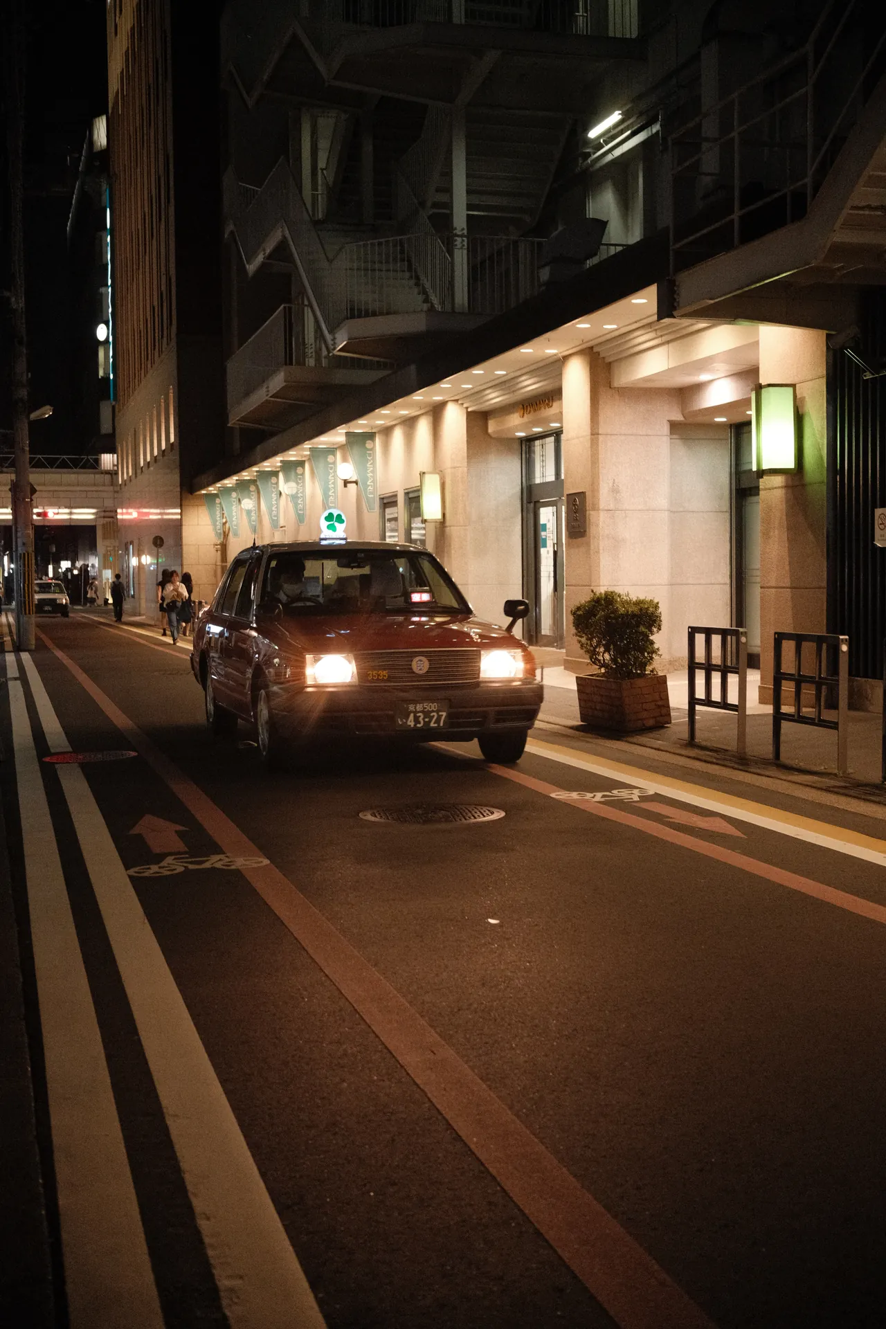Táxi com os faróis acesos numa rua do Japão à noite