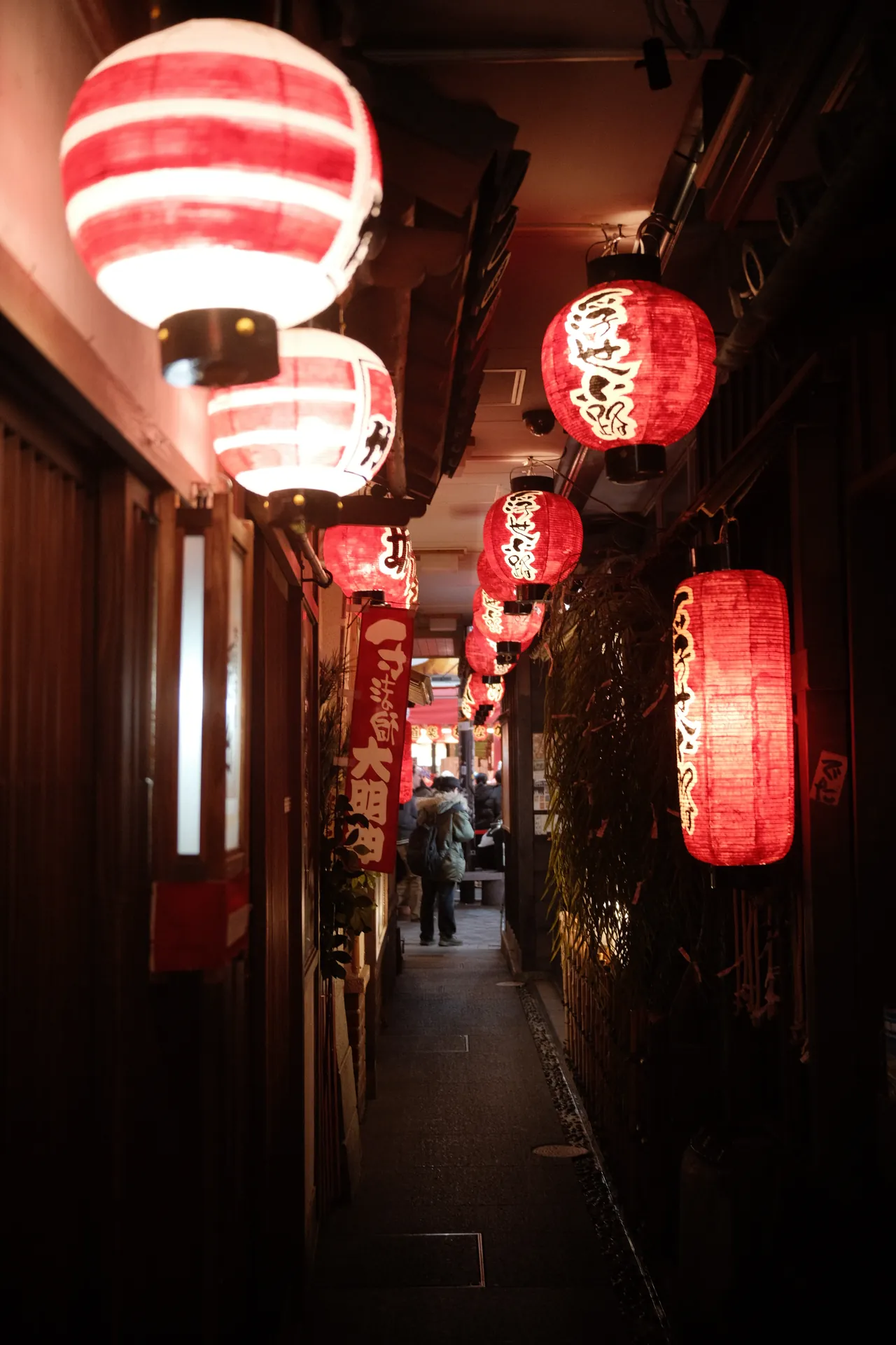 Viela estreita com lanternas vermelhas acesas em Namba, Osaka